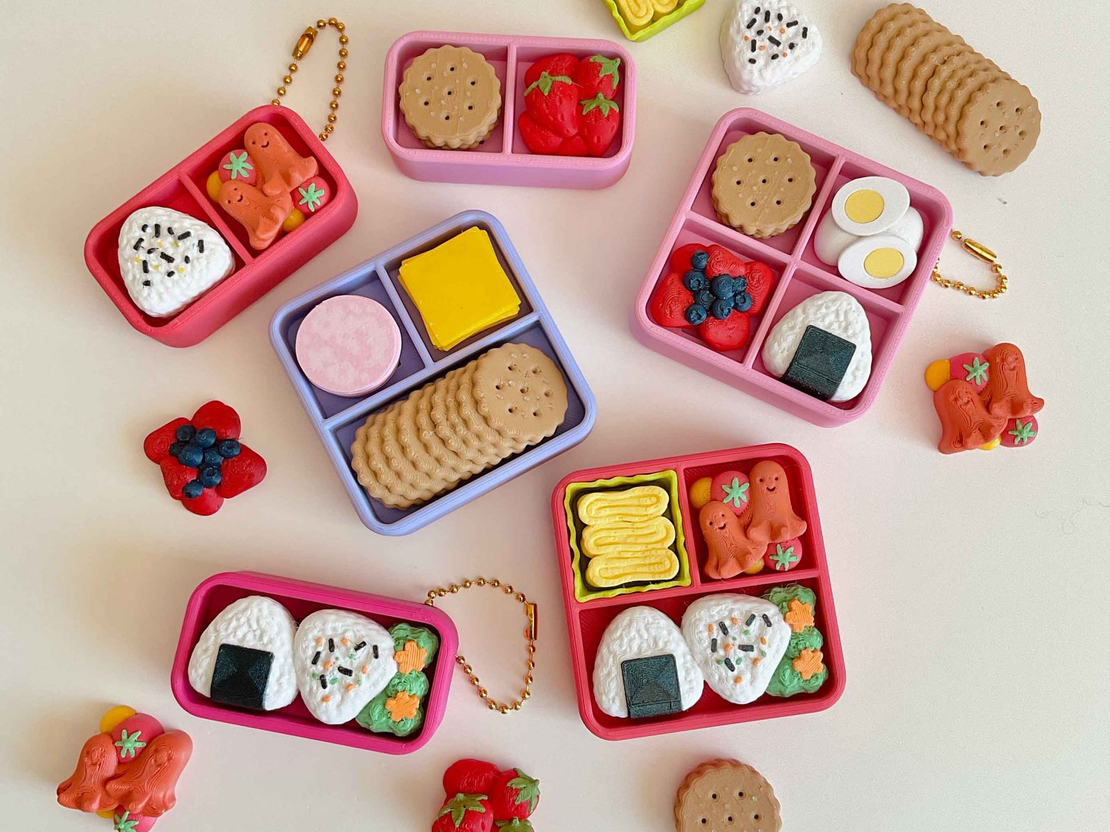 Printed bento box clickers filled with rice balls, sausages, cookies and berries
