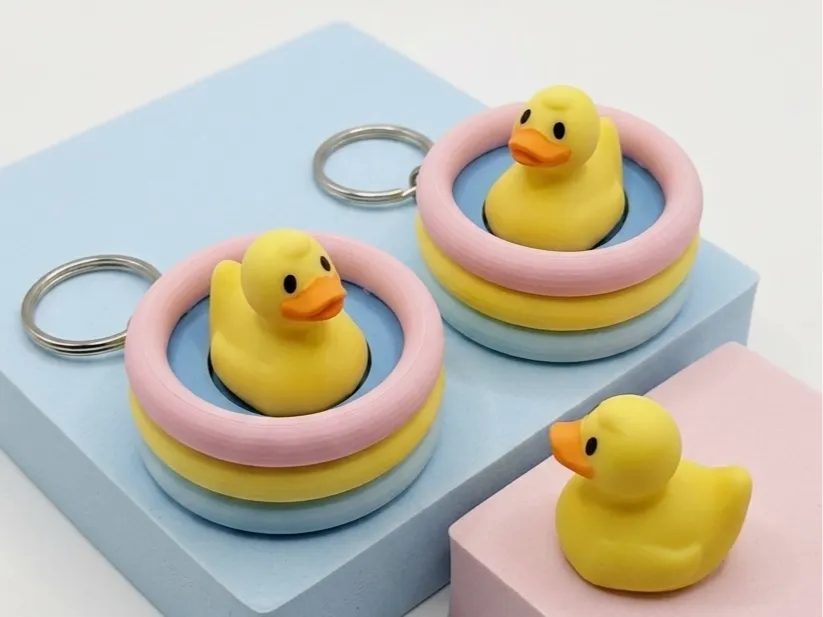 Rubber duck keychain clickers sitting in stacks of pastel pool rings