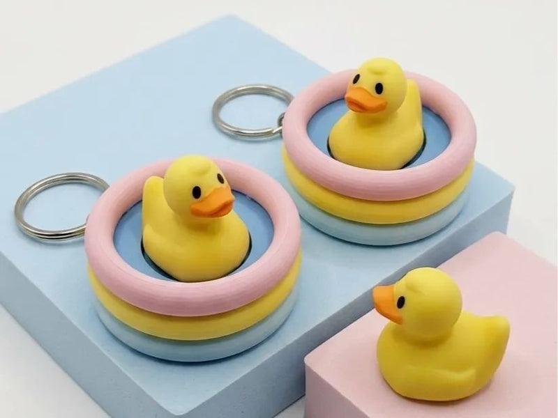 Rubber duck keychain clickers sitting in stacks of pastel pool rings